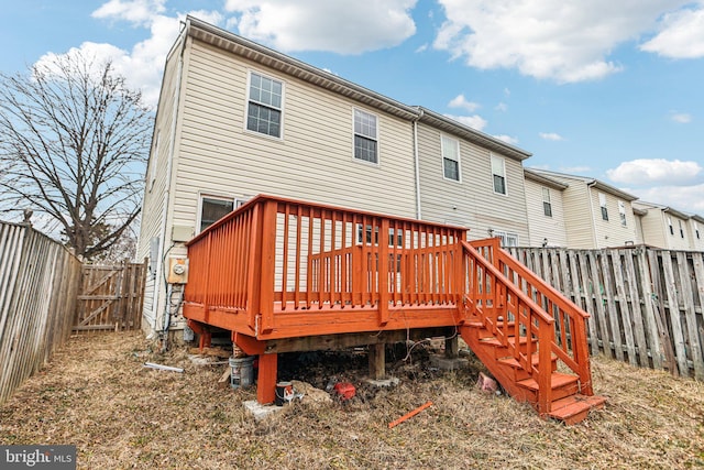 rear view of house featuring a fenced backyard and a deck