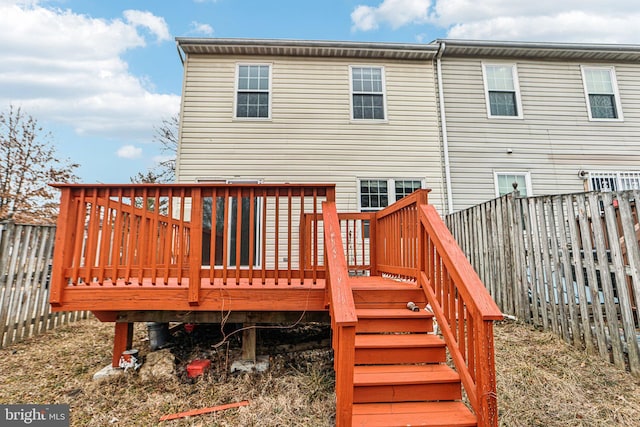 wooden terrace with a fenced backyard