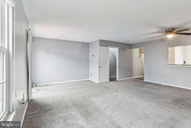 unfurnished room featuring a ceiling fan, carpet flooring, a textured ceiling, and baseboards