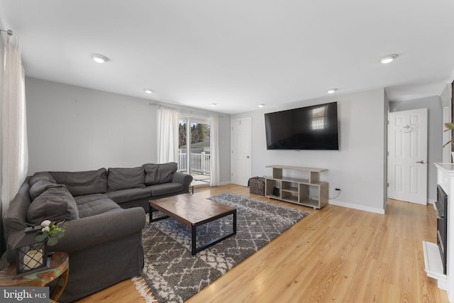 living area featuring recessed lighting, a fireplace, wood finished floors, and baseboards