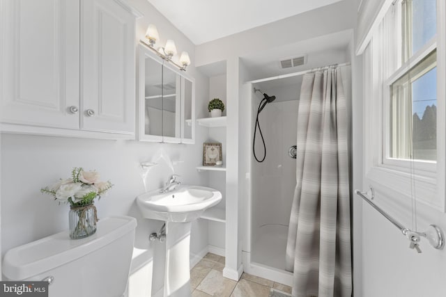 bathroom featuring toilet, a stall shower, baseboards, and visible vents