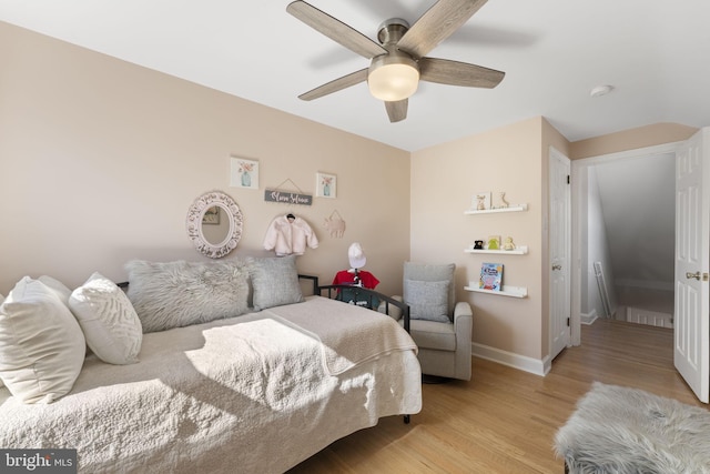 bedroom featuring ceiling fan, baseboards, and wood finished floors