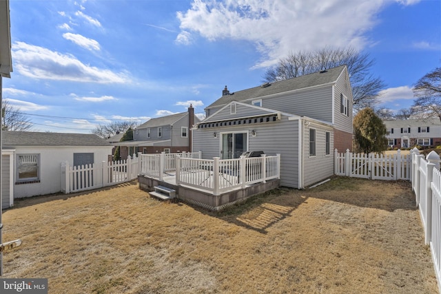 back of house with a lawn, a fenced backyard, and a wooden deck