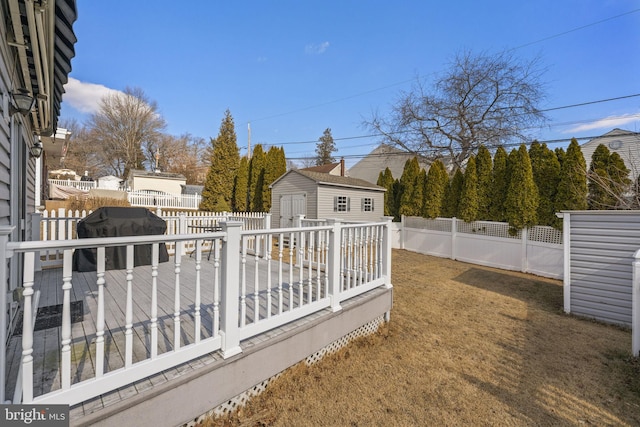 view of yard featuring an outbuilding, a storage unit, a fenced backyard, and a wooden deck