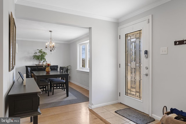 foyer featuring light wood-style floors, baseboards, ornamental molding, and a chandelier