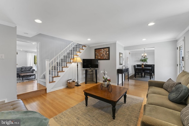 living room featuring ornamental molding, stairway, wood finished floors, and baseboards