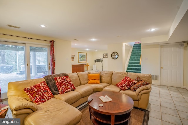 living room featuring light tile patterned floors, visible vents, recessed lighting, and stairs