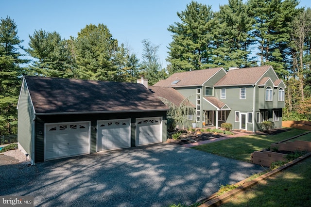 view of front of home featuring a garage, a chimney, and a front lawn