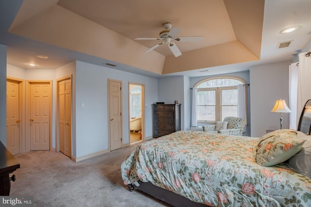 bedroom featuring visible vents, light colored carpet, baseboards, and a tray ceiling