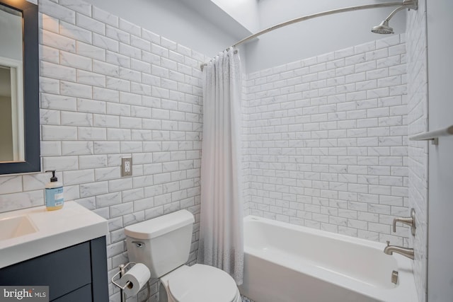 full bath with vanity, toilet, tile walls, and shower / tub combo