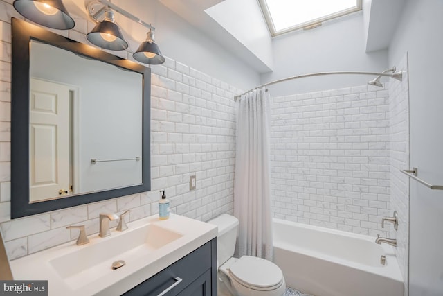 full bath featuring toilet, tile walls, a skylight, shower / bath combination with curtain, and vanity