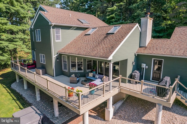 back of house with a chimney, an outdoor hangout area, a shingled roof, and a deck