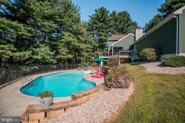 view of swimming pool featuring fence, a fenced in pool, a yard, a deck, and a patio area