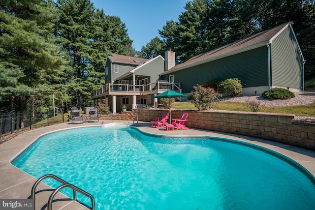 view of swimming pool featuring a fenced in pool, a patio, a deck, and fence