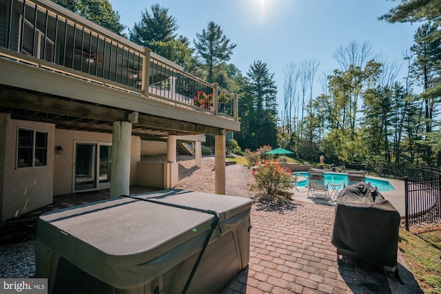 view of patio with a fenced in pool, fence, a wooden deck, area for grilling, and a hot tub