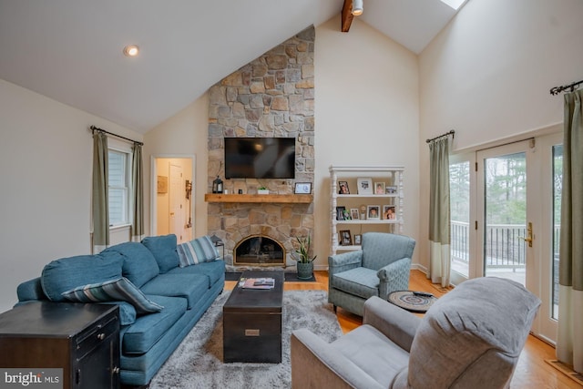 living room featuring beam ceiling, a fireplace, high vaulted ceiling, and light wood-style floors