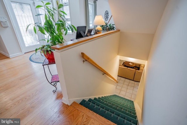 staircase with baseboards and wood finished floors