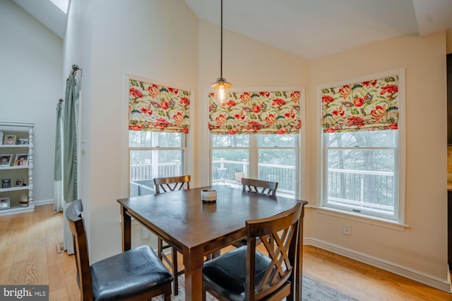 dining space featuring lofted ceiling, plenty of natural light, and light wood finished floors