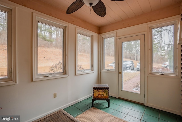 unfurnished sunroom with wood ceiling and ceiling fan