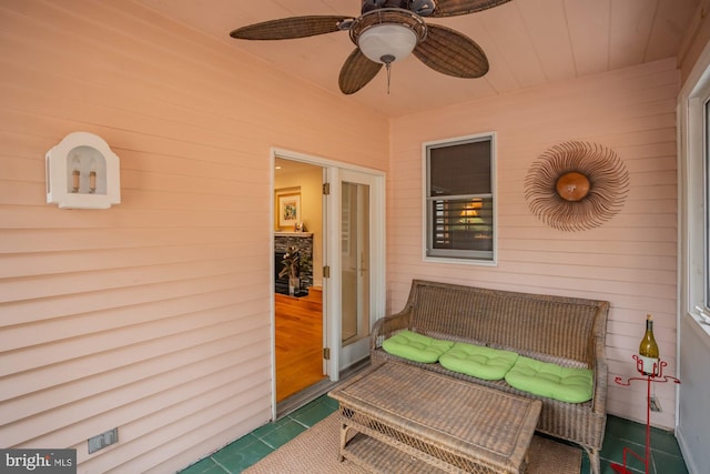 sunroom / solarium featuring a ceiling fan