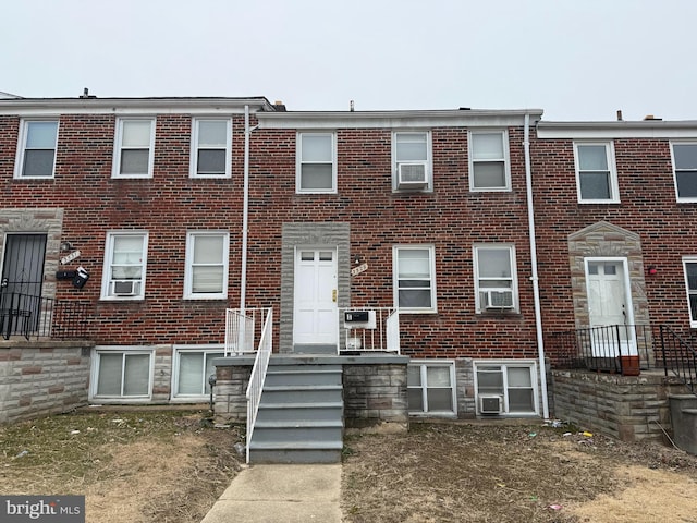 view of property with brick siding and cooling unit