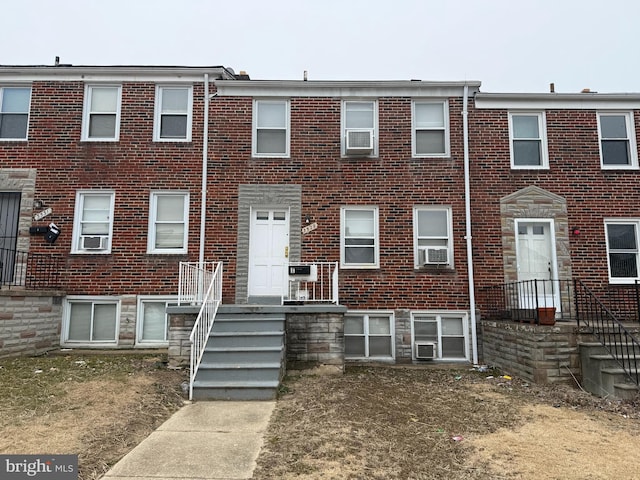 view of property with cooling unit and brick siding