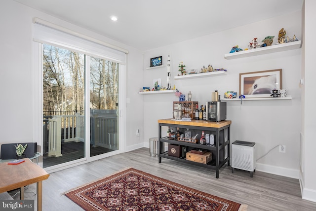 doorway featuring baseboards, wood finished floors, and recessed lighting