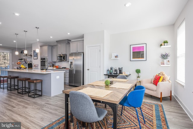 dining space featuring light wood-style floors, baseboards, and recessed lighting