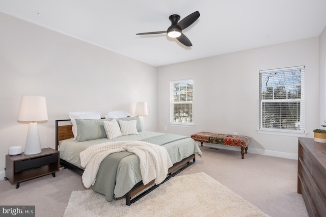 bedroom featuring a ceiling fan, light colored carpet, and baseboards