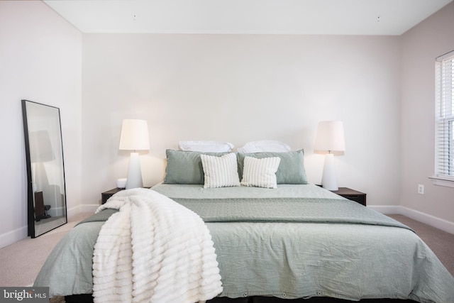 bedroom featuring carpet and baseboards