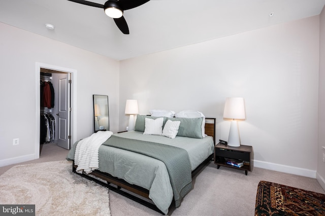 bedroom with baseboards, a spacious closet, and light colored carpet