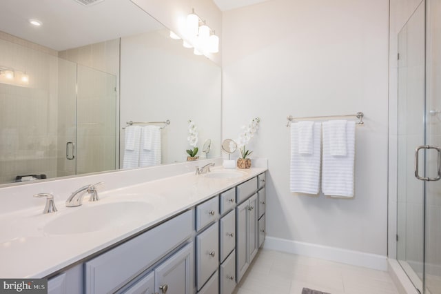 full bath featuring a sink, a shower stall, baseboards, and double vanity