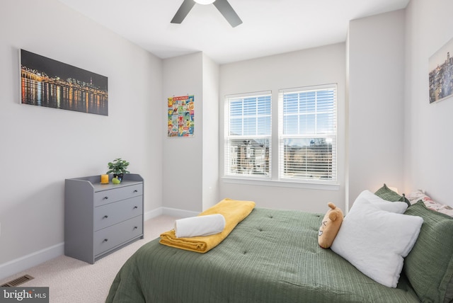 bedroom featuring a ceiling fan, light colored carpet, visible vents, and baseboards