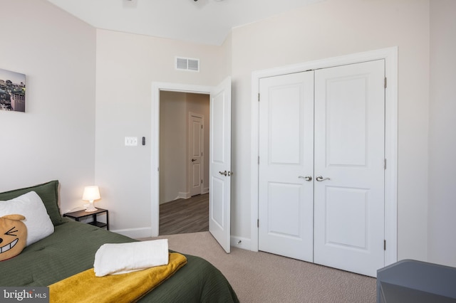 bedroom featuring carpet floors, a closet, visible vents, and baseboards