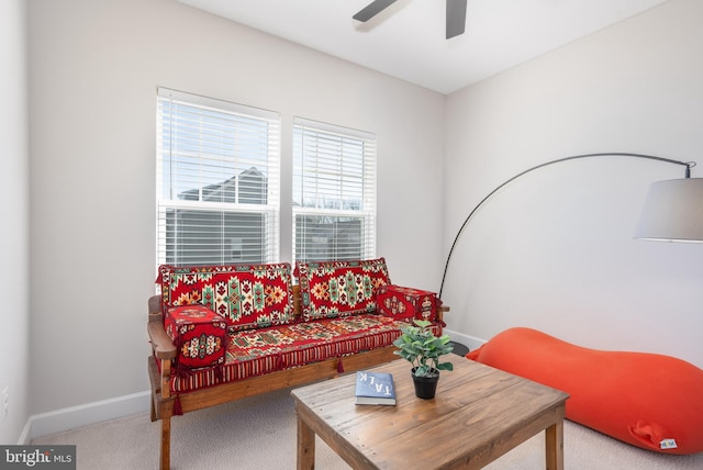 living room with a ceiling fan, carpet, and baseboards