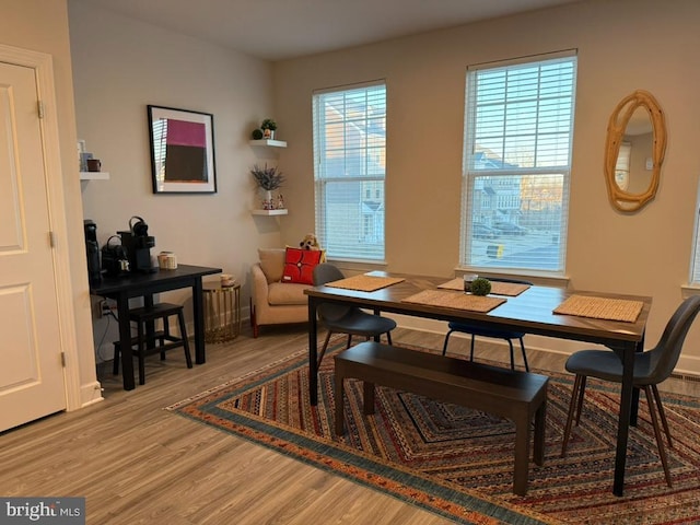 dining area with baseboards and wood finished floors