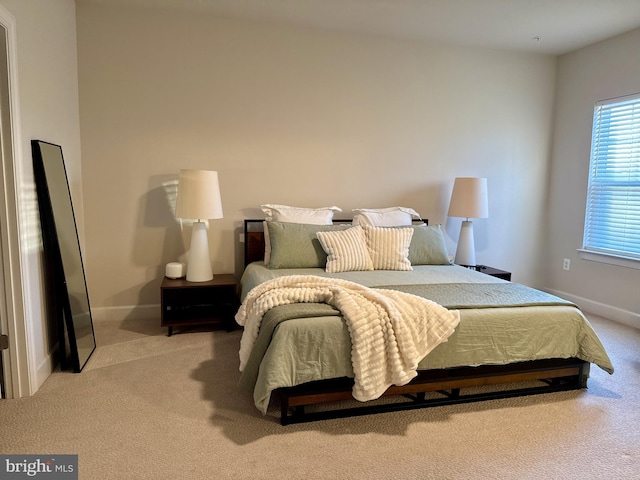 bedroom with light carpet and baseboards