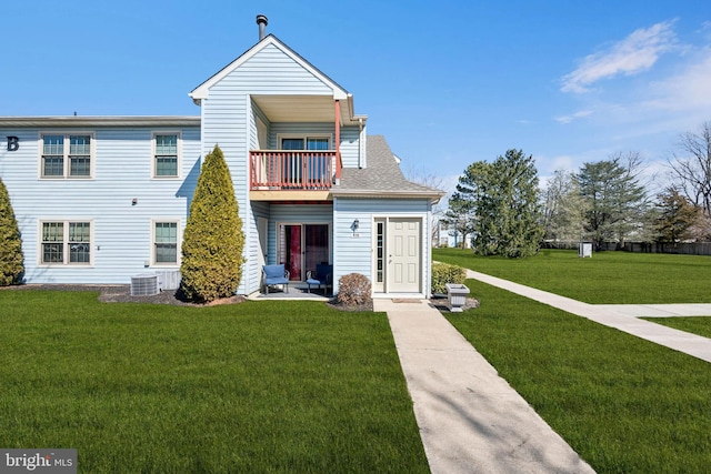 back of property with a balcony, cooling unit, a lawn, and roof with shingles