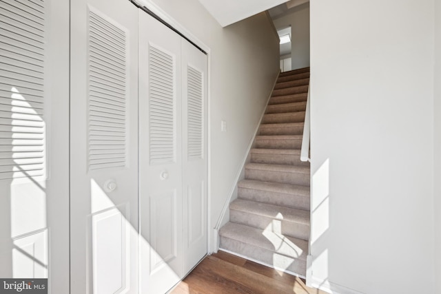 stairway with wood finished floors and baseboards