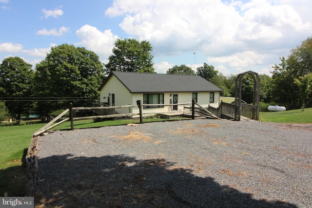 view of front of property with a deck, a front lawn, and fence