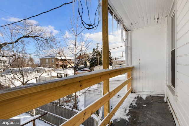 view of snow covered back of property