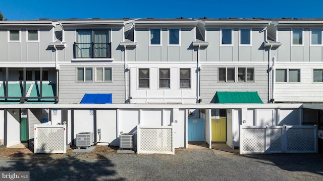 rear view of property featuring central air condition unit and board and batten siding