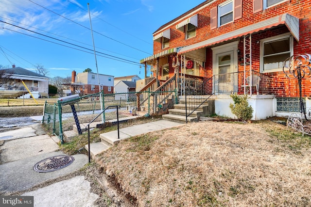 view of front facade with fence and brick siding