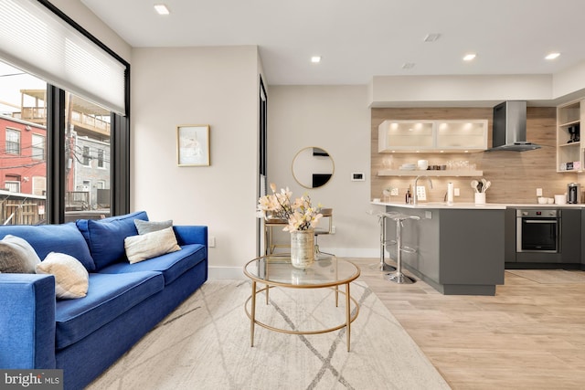 living room featuring sink and light hardwood / wood-style floors