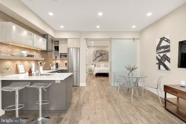 kitchen featuring appliances with stainless steel finishes, sink, a barn door, kitchen peninsula, and a breakfast bar area