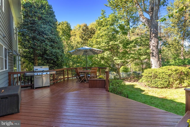 wooden deck with outdoor dining space and area for grilling