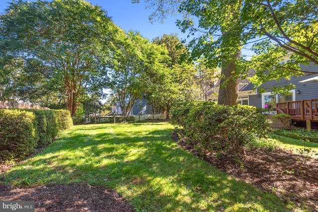 view of yard with fence and a wooden deck