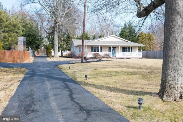 single story home featuring covered porch and a front lawn