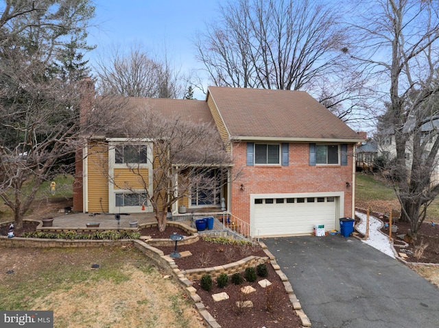 view of front facade with aphalt driveway, brick siding, and an attached garage