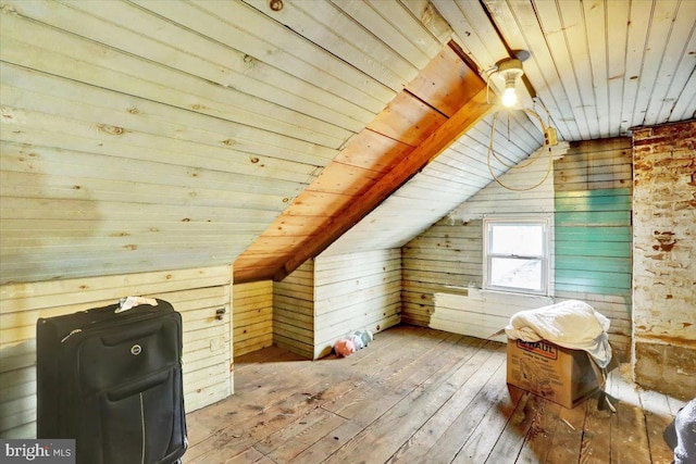 bonus room featuring lofted ceiling, wooden ceiling, wood walls, and wood finished floors